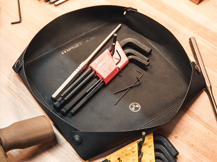 Large Magpul DAKA Magnetic Field Tray filled with tools on workbench next to rifle with MOE MVG